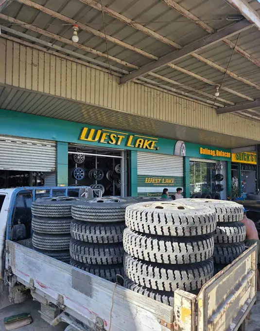 Truck tires loaded on a pickup in front of the shop