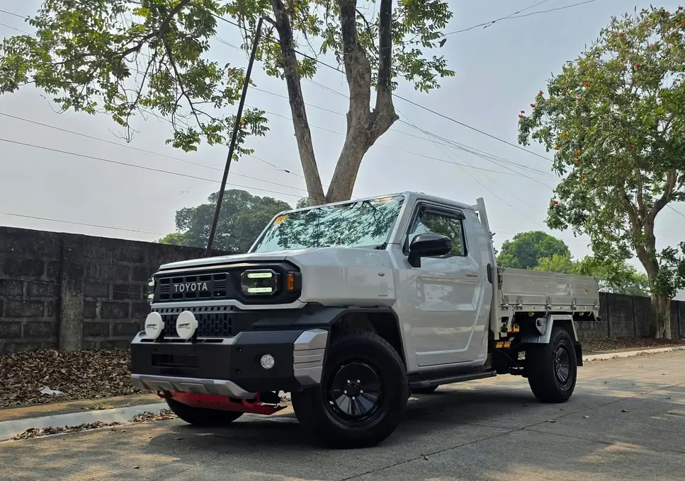 A white Toyota pickup on black wheels